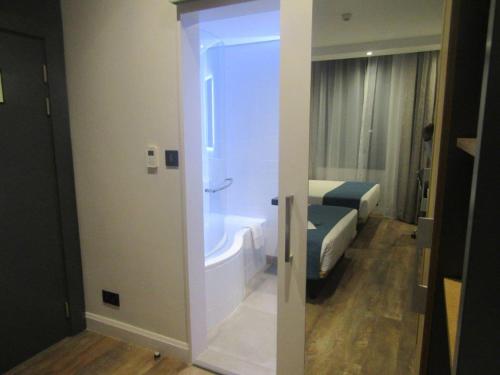 a bathroom with a tub and a bed in a room at Garden Court Kitwe in Kitwe