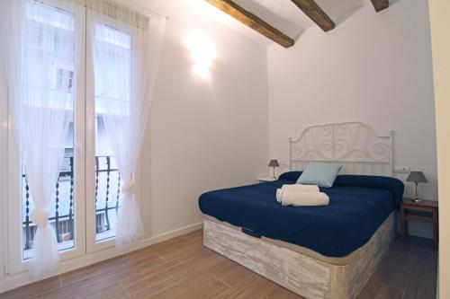 安波拉的住宿－Bonito Loft en L'Ampolla，一间卧室设有蓝色的床和窗户。