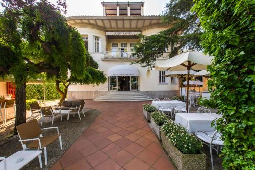 un patio extérieur avec des tables et des chaises en face d'un bâtiment dans l'établissement Hotel Villa Mabapa, sur le Lido de Venise