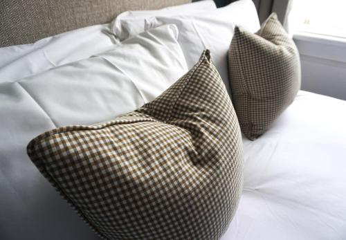 a bed with two checkered pillows on it at The Beverley Arms Hotel in Beverley