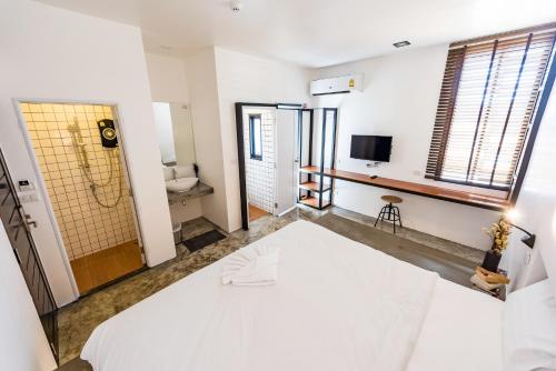 a bedroom with a white bed and a bathroom at Book a Bed Poshtel - SHA Plus in Phuket Town