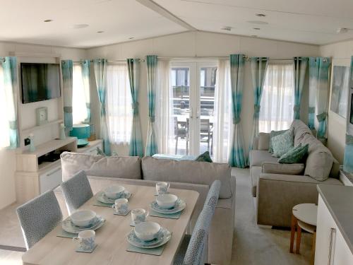 a living room with a table and a couch at New Forest Lodges Bashley Park in New Milton