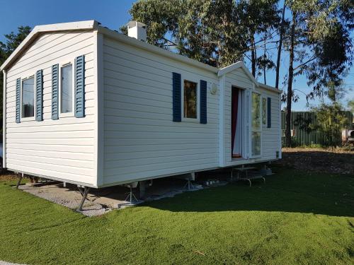 a white tiny house sitting on top of a yard at Rota da vila-Quinta das Rãs in Foz do Sousa