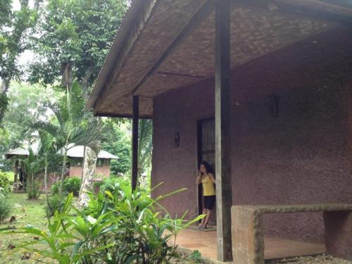 a woman standing in the doorway of a house at Bambua Nature Cottages in Puerto Princesa City
