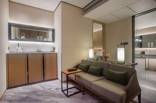 una sala de estar con un sofá y una mesa en Yuluxe Hotel Chengdu, en Chengdú