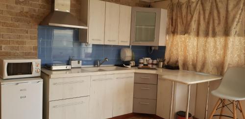 a small kitchen with white cabinets and a sink at Shahal Apartments in Beer Sheva