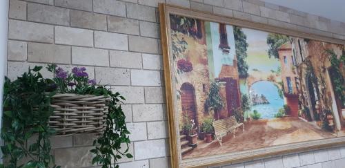 a painting on a wall with a basket of flowers at Shahal Apartments in Beer Sheva