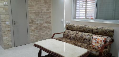 a room with a couch and a table and a window at Shahal Apartments in Beer Sheva