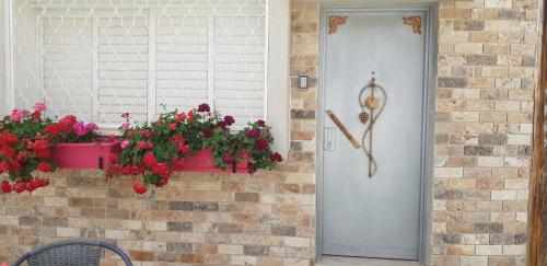a door with a window with flowers in a flower box at Shahal Apartments in Beer Sheva