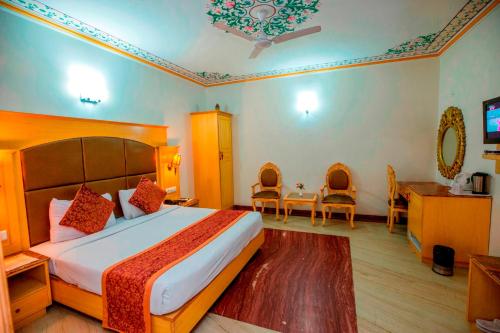 a hotel room with a bed and a table and chairs at Nahargarh Haveli-Near Train station Metro in Jaipur