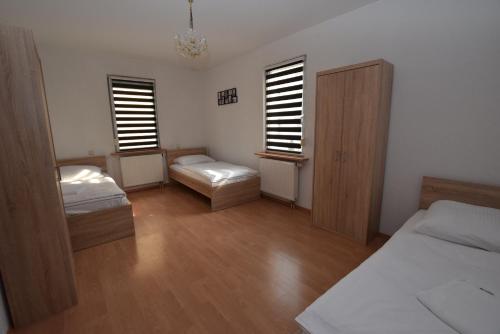 a bedroom with two beds and two windows at Apartment Stuttgart Südheim in Stuttgart