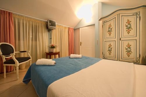 a hotel room with a bed and a chair at Elena Hotel in Parga