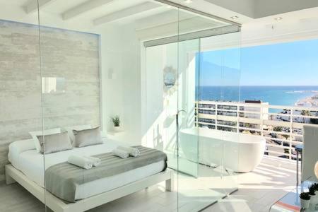 トレモリノスにあるLoft del Mar - Charming luxury apartment at La Rocaの白いバスルーム(バスタブ、ベッド、バスタブ付)
