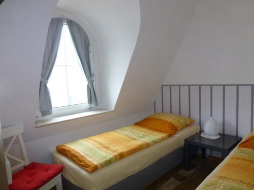- une petite chambre avec un lit et une fenêtre dans l'établissement Villa Marina Wangerooge, à Wangerooge