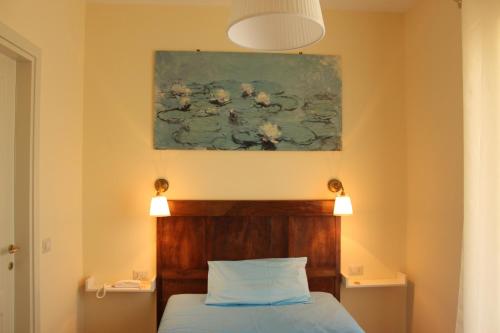 a bedroom with a bed and a painting on the wall at B&B Il Falco e l'Ulivo in Rocca Massima