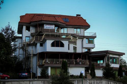a large white building with a red roof at Семеен хотел Кристал in Smolyan