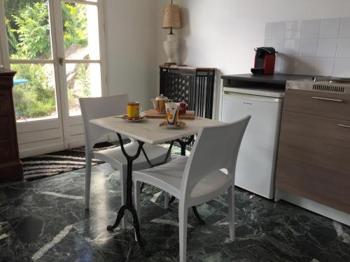 a kitchen with a table and two chairs and a table and a table at La maison du lac in Auvers-sur-Oise