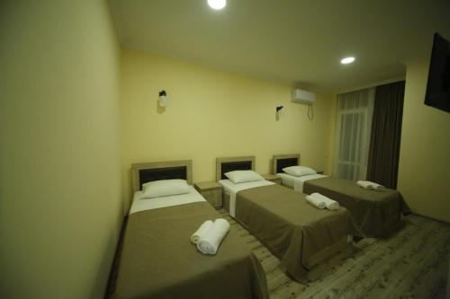 a room with three beds in a room at Hotel Comfort in Kutaisi