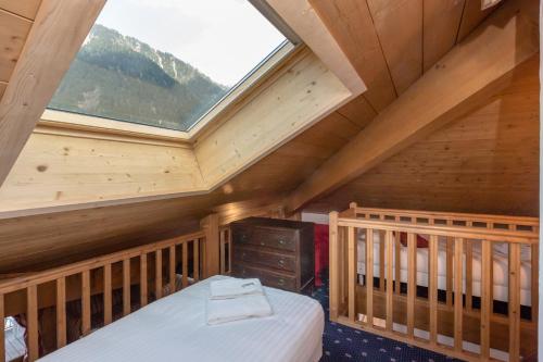 - une chambre en mezzanine avec un lit et une fenêtre dans l'établissement Polaris - Chamonix, à Chamonix-Mont-Blanc