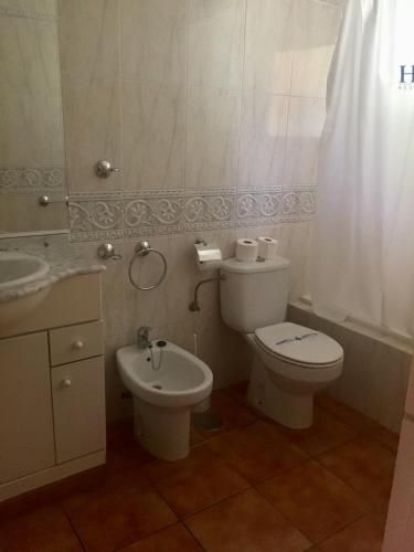 a bathroom with a white toilet and a sink at Marbesa Villas with Jacuzzi in Marbella