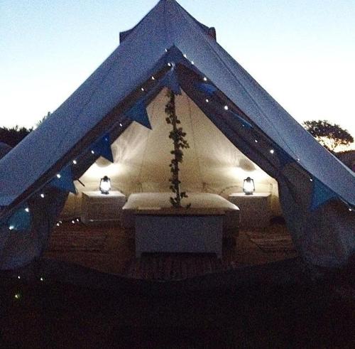 a blue tent with lights and a table in it at Wold Farm Bell Tents in Flamborough