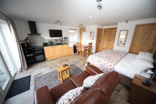 a bedroom with a bed and a couch at Lynton Lodge Studios in Keswick