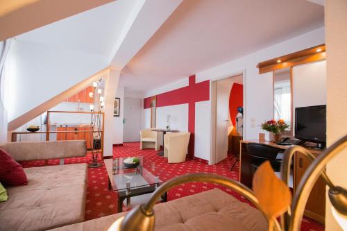 a living room with a couch and a table at Hotel Berlin in Leipzig