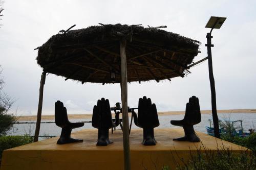 a table and chairs under an umbrella on the beach at Lotus an Eco Resort Konark in Konārka