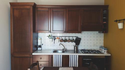 a kitchen with wooden cabinets and a sink at Casa Duci in Agrigento