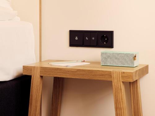 a small wooden table with a box on it at Schwabinger Wahrheit by Geisel in Munich