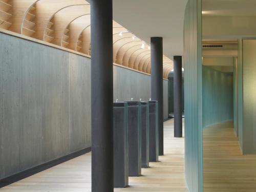 a row of black poles in a hallway with wood floors at Schwarzer Adler Kitzbühel - Adults Only in Kitzbühel