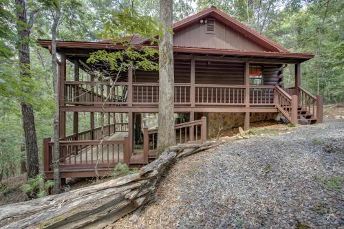 a log cabin in the woods with a wrap around porch at River Ranch in Ellijay