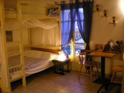 a bedroom with bunk beds with a desk and a desk at Adonis Guesthouse in Batsi
