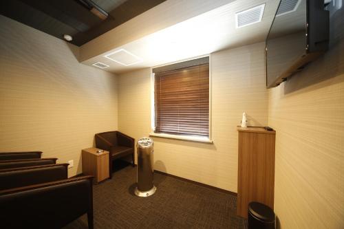 a waiting room with a radiator and a window at Natural Hot Spring Shoun no Yu Dormy Inn Kofu Marunouchi in Kofu