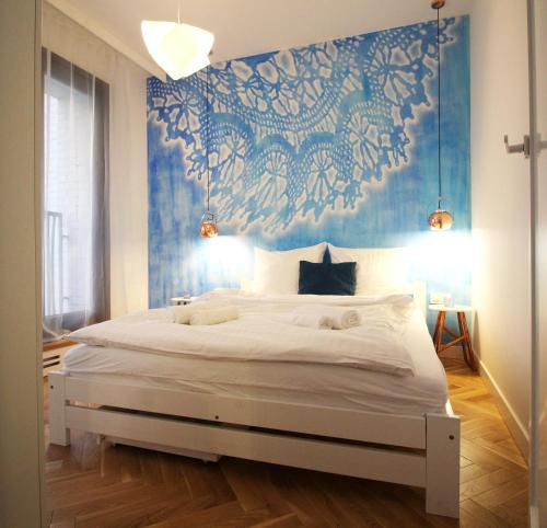 ワルシャワにあるoompH Warsaw Central STREET ART Apartmentsの青い壁のベッドルーム1室(大型ベッド1台付)