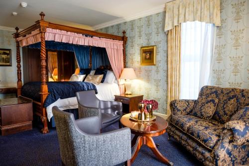 um quarto de hotel com uma cama e um sofá em The Gretna Chase Hotel em Gretna