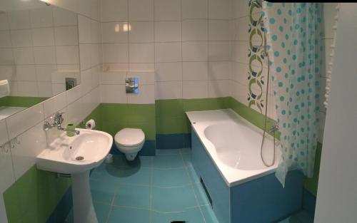 łazienka z umywalką, wanną i toaletą w obiekcie SANTOSA Pokoje Goscinne w Zielonej Górze
