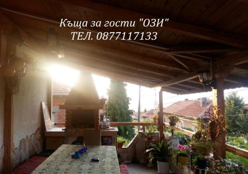 a view of a patio with a table and a fireplace at Къща за гости Ози in Ovchartsi