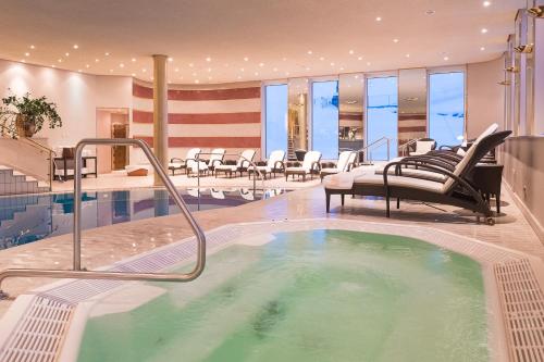 a hot tub in a hotel with chairs and tables at Hotel Zürserhof in Zürs am Arlberg