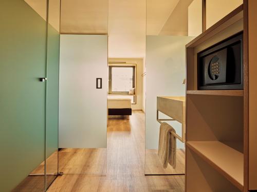 a small apartment with a glass door leading to a bedroom at Schwabinger Wahrheit by Geisel in Munich