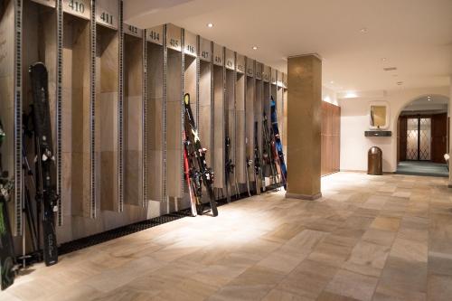 a room with a bunch of skis on the wall at Hotel Zürserhof in Zürs am Arlberg