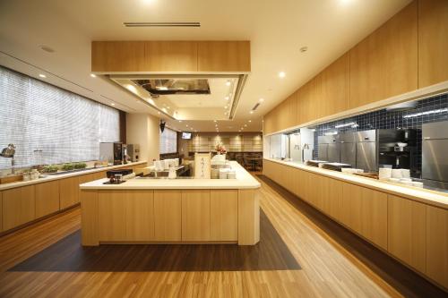 a large kitchen with a large island in the middle at Natural Hot Spring Shoun no Yu Dormy Inn Kofu Marunouchi in Kofu
