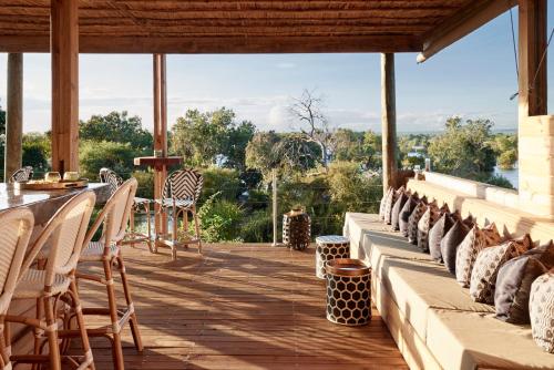 a patio with chairs and a table with a view at Victoria Falls River Lodge in Victoria Falls