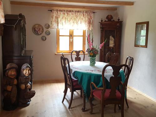 Wyspa Świerków في Lipusz: غرفة طعام مع طاولة وكراسي ونافذة