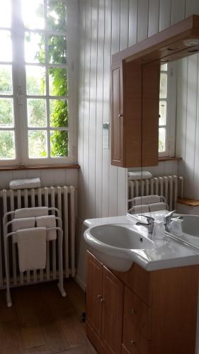 y baño con lavabo y espejo. en Hotel du Golf de Clécy, en Clécy