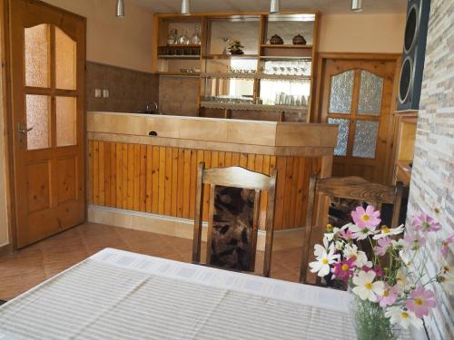 a kitchen with a bar with a table and flowers at Орбелус in Govedartsi