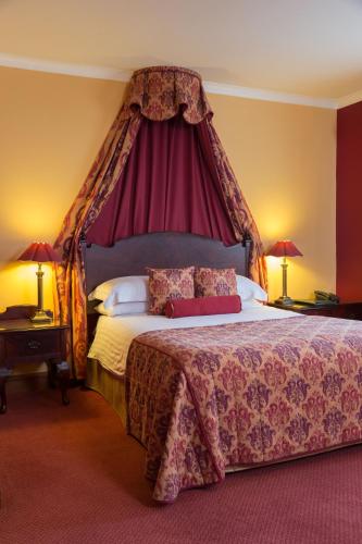 a bedroom with a large bed with a canopy at Best Western Sysonby Knoll Hotel in Melton Mowbray