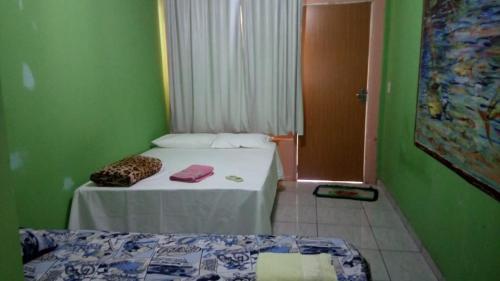 a room with two beds in a room with green walls at Estância Cyclo das Águas in Nobres