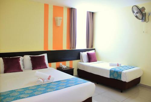 a hotel room with two beds and a window at Sun Inns Hotel Pasir Penambang (KS Botanic) in Kuala Selangor