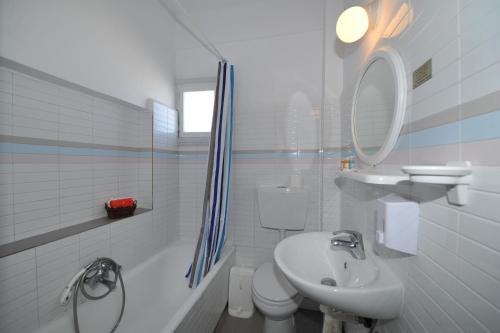 bagno bianco con lavandino e servizi igienici di King Thiras Hotel a Firà